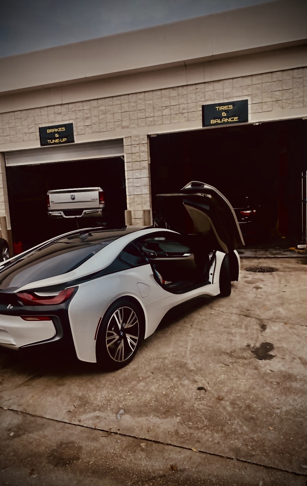 Technician under vehicle lift performing multi-point safety inspection